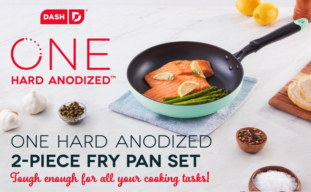 One Hard Anodized Fry Pan holding a freshly cooked meal of salmon and asparagus, topped with lemon.