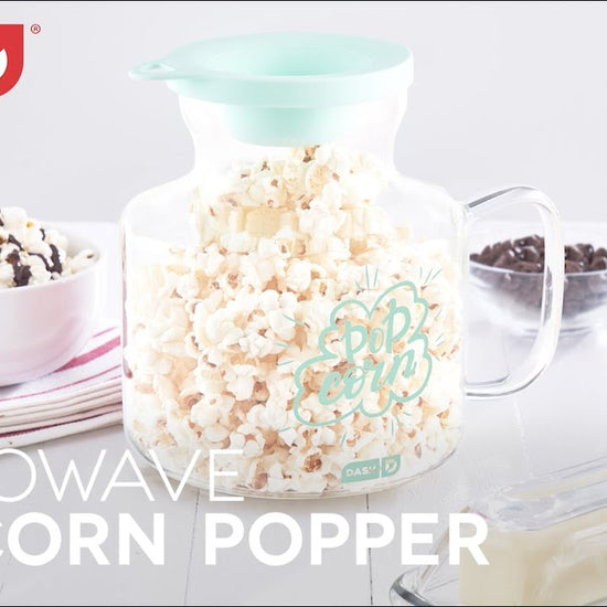 Kernels are added to the popcorn popper using the measuring lid and the recipe guide is shown.