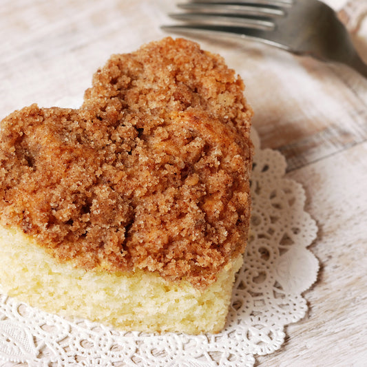 A heart shaped cinnamon sugar coffee cake on a doily.