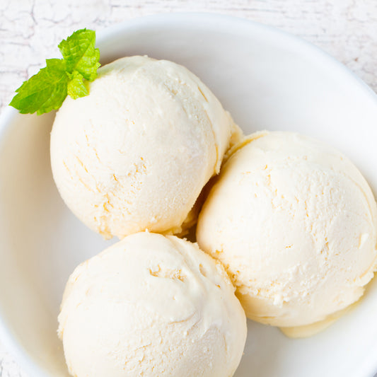 Three scoops of vanilla ice cream in a white bowl.
