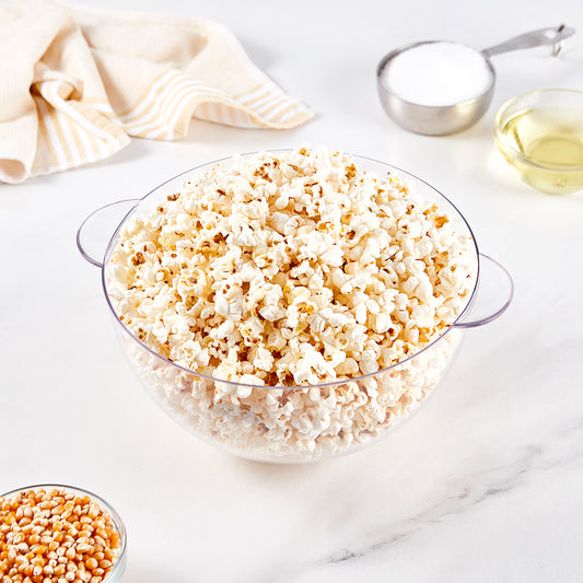 A clear bowl filled with buttered popcorn.