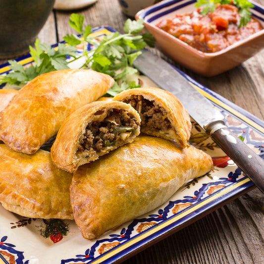 Beef empanadas on a square plate.