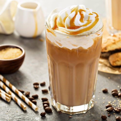 Salted caramel mocha coffee in a tall clear glass topped with whipped cream and caramel.