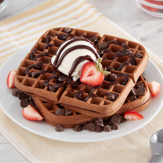 Two 7" chocolate waffles topped with chocolate chips, strawberries, chocolate drizzle, and one scoop of vanilla ice cream.