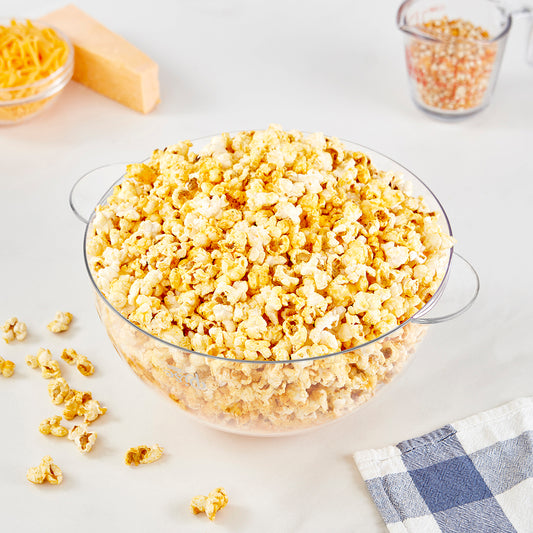 A clear bowl filled with cheddar popcorn.