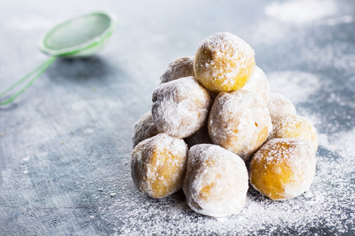 A stack of Classic Powdered Donut Bites on a gray counter.