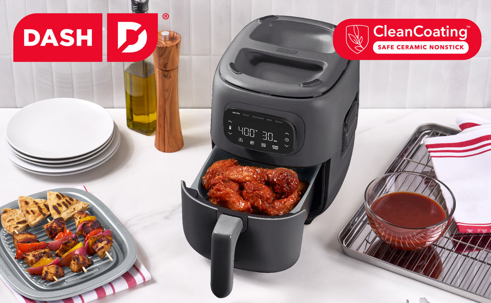 Dash air fryer with food on a white surface, featuring the Dash brand and CleanCoating label.