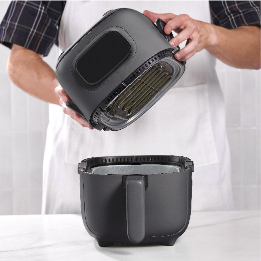 Person holding a black 3QT Flip & Fry™ Digital 2-in-1 Grill + Air Fryer Air Fryer Dash Forged Iron