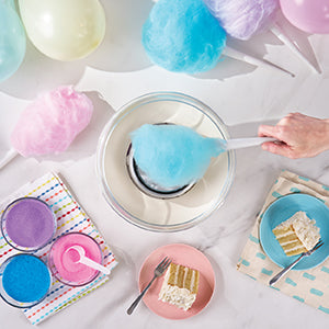 Person using a  Dash Cotton Candy Maker to serve blue cotton candy.