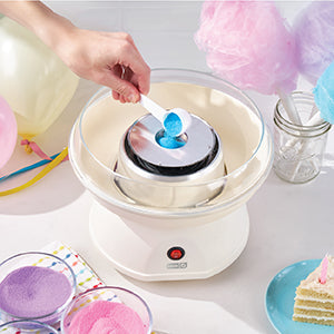 Cotton candy machine with pink and purple cotton candy on a white surface.