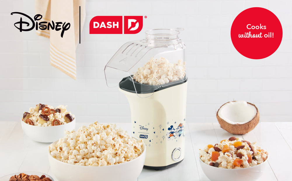 Disney popcorn maker with bowls of popcorn and ingredients on a white background