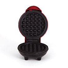 Black waffle maker with red handle on a white background