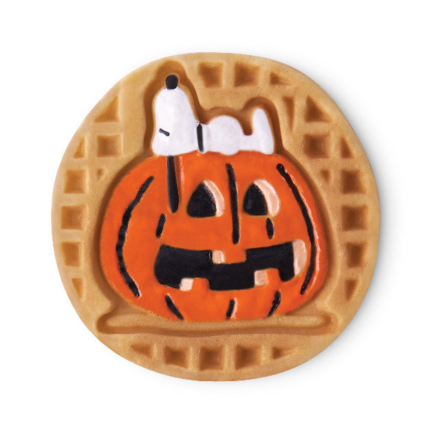 Halloween-themed cookie with a pumpkin design and a Snoopy on top, on a white background.