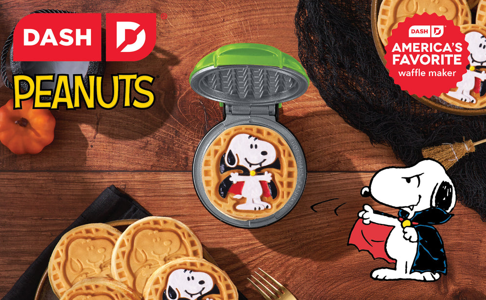 Snoopy-themed waffle maker with cookies on a wooden surface, featuring Dash and Peanuts logos.