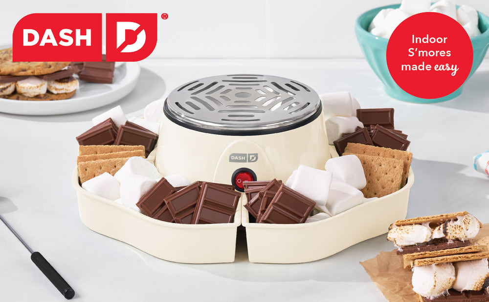 Dash s'mores maker with ingredients on a white surface, featuring the Dash brand logo.