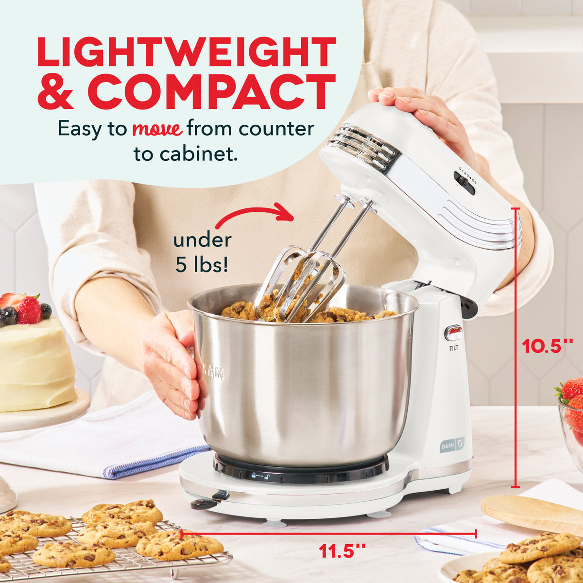 White stand mixer with stainless steel bowl and three beaters, 10.5" tall and 11.5" wide, mixing cookie dough.