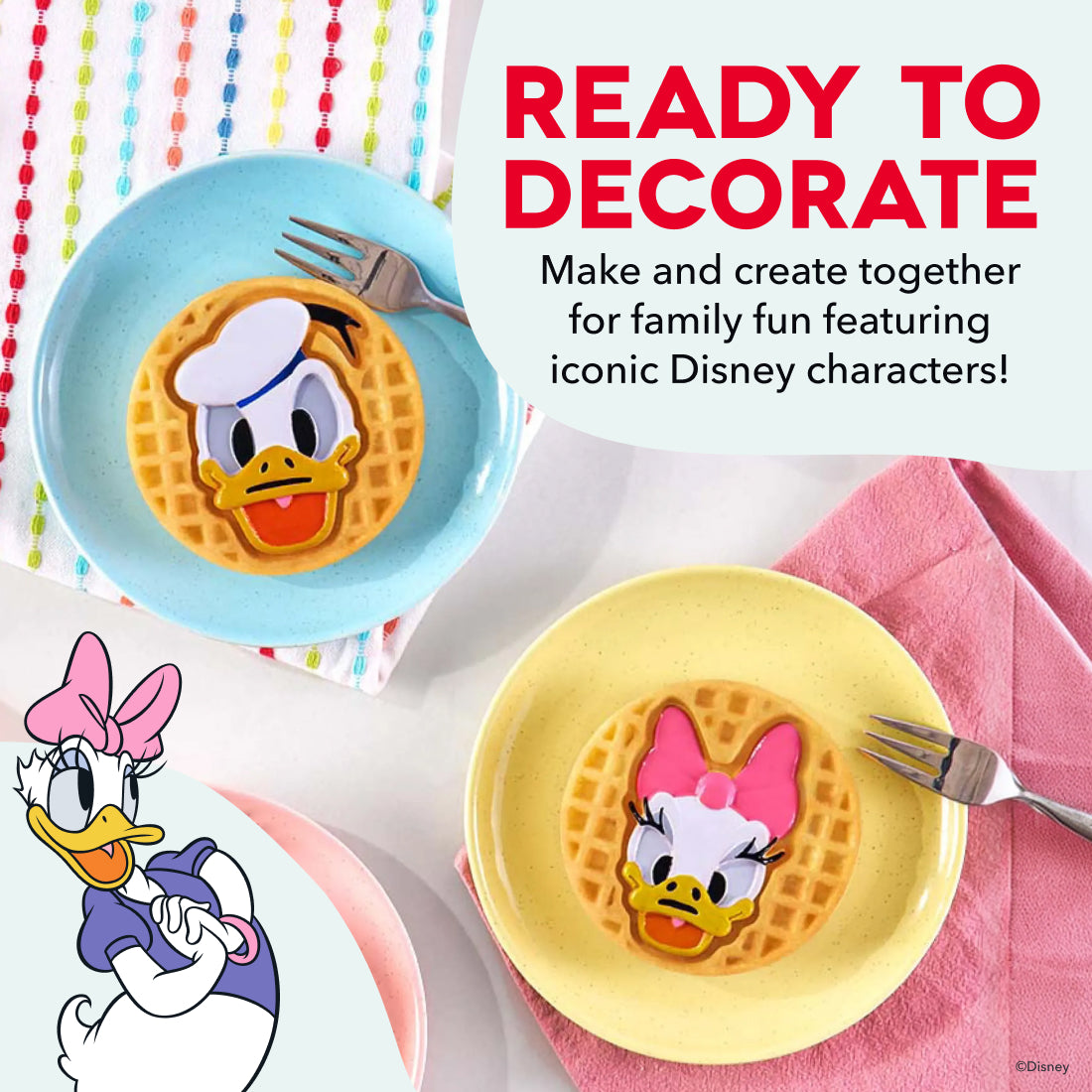 Blue and yellow plates with Disney character waffle designs, metal forks, and colorful beaded garland on white surface.
