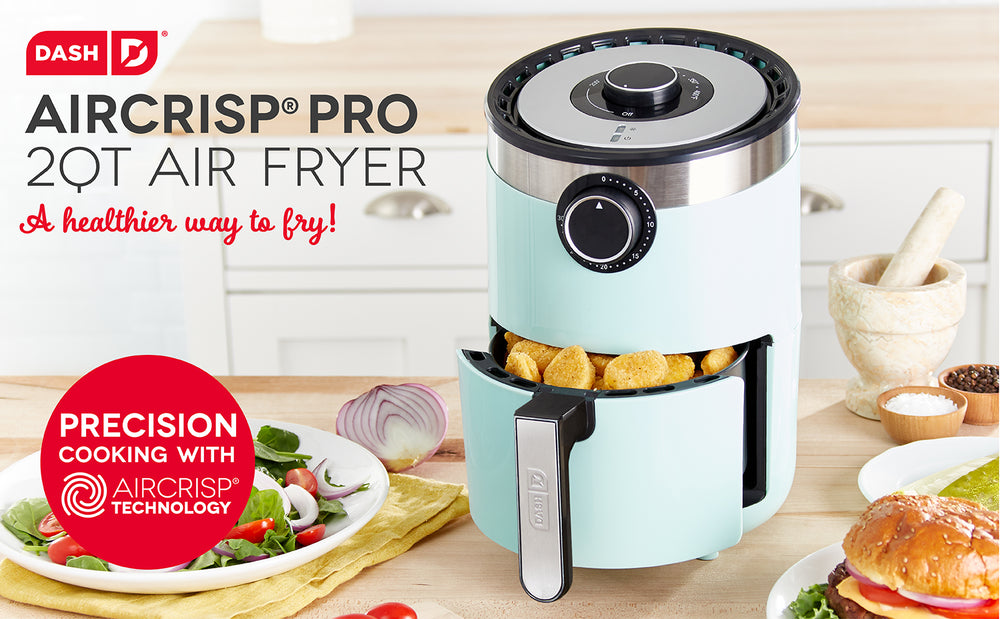 An Aircrisp Pro Digital Air Fryer 2 Quart sits ajar on a wooden countertop next to the tagline, “A healthier way to fry!” 