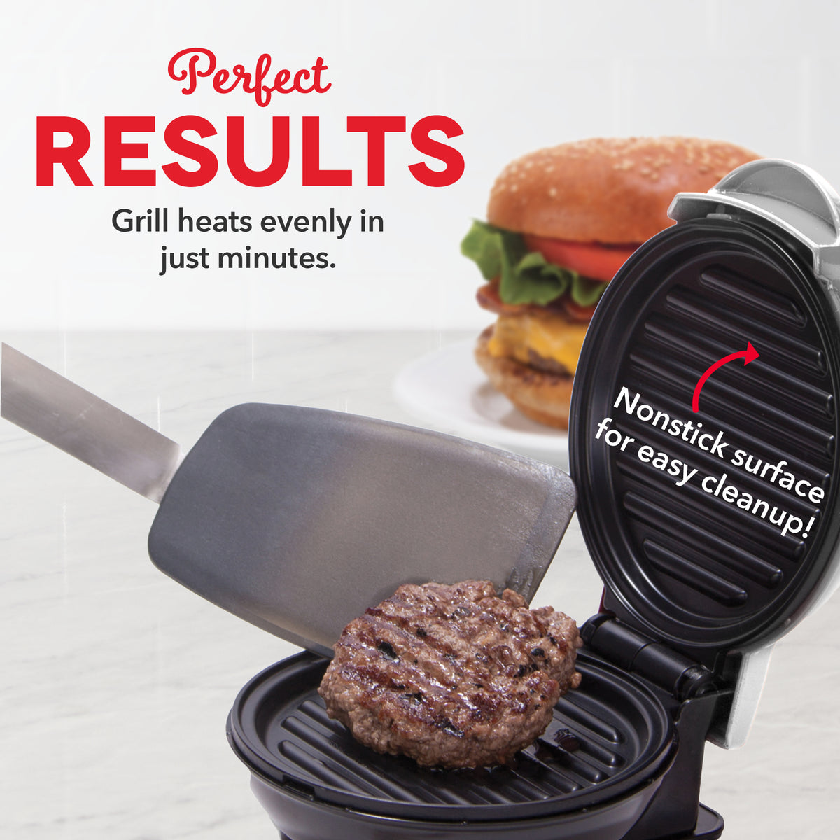 Compact grill with nonstick ridged cooking surface and spatula, shown cooking a beef patty with finished burger in background