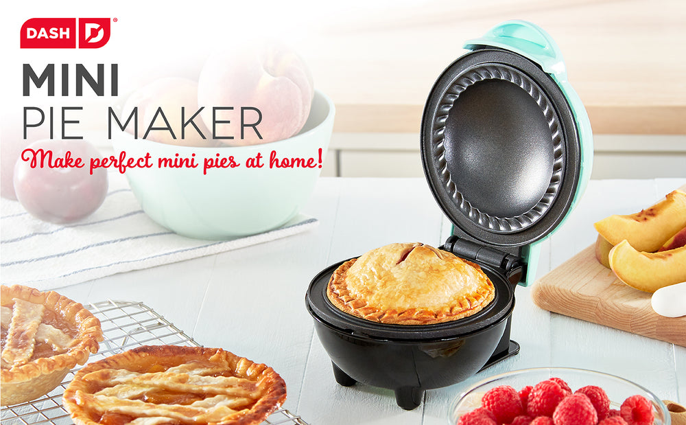 An aqua colored mini pie maker sits open on a white counter.