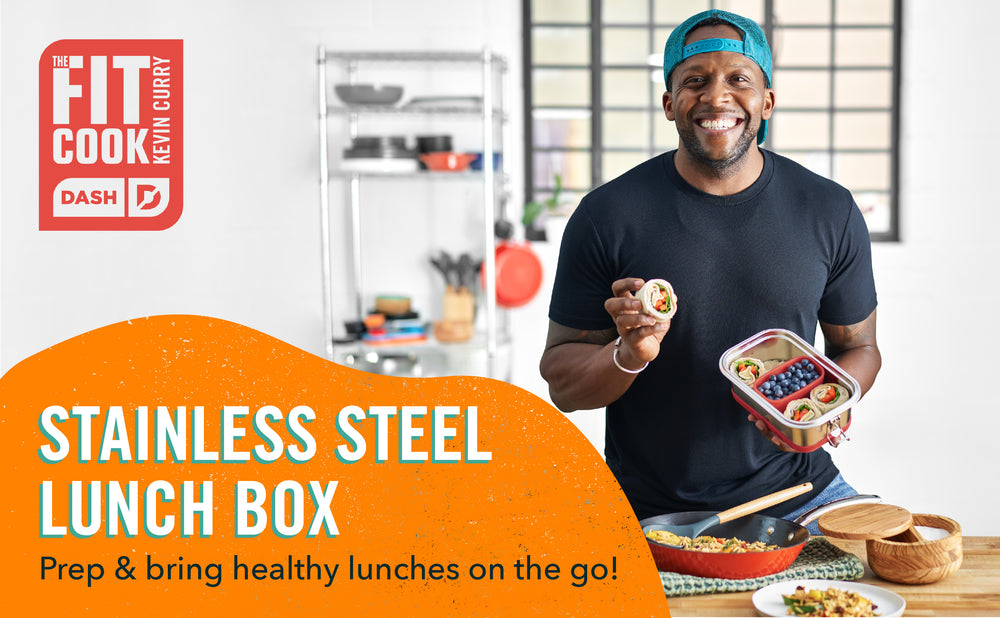 Kevin Curry stands smiling wearing a blue backwards cap and holding up a lunch in the stainless steel lunch box.
