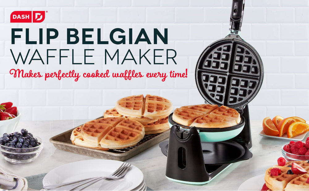 The Flip Belgian Waffle Maker open alongside a spread of waffles and fruit.