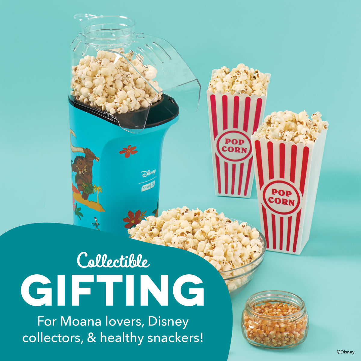 Turquoise popcorn maker with Disney character design, filled with popcorn, surrounded by red and white striped popcorn contai
