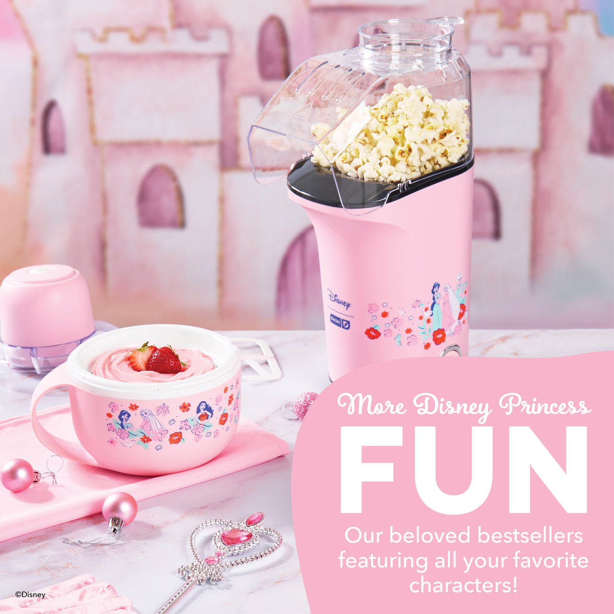 Pink Disney Princess popcorn maker with popped corn in top chamber, matching bowl with whipped cream and strawberry below.