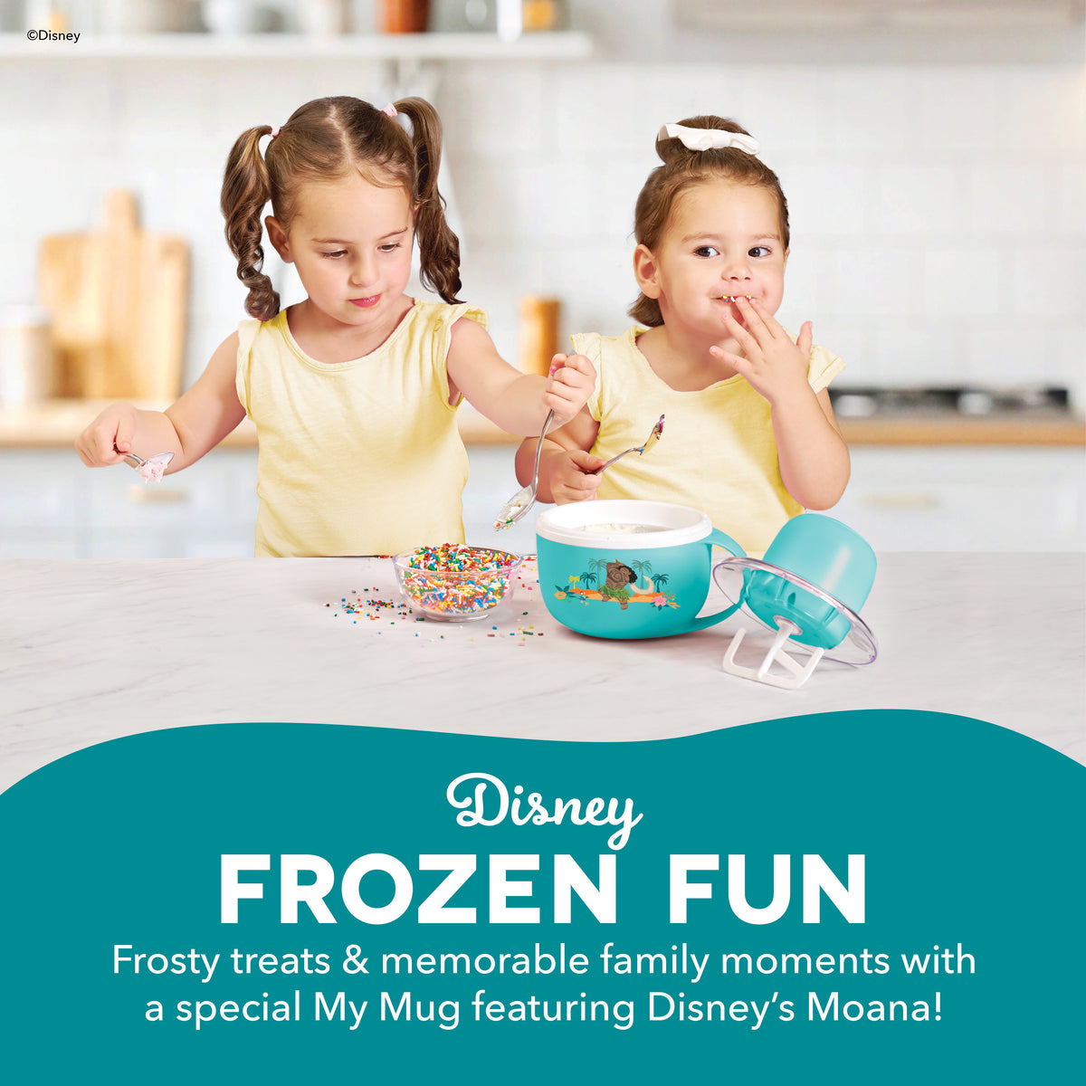 Two young children in yellow shirts using a turquoise mug-shaped ice cream maker with sprinkles and accessories on a kitchen 