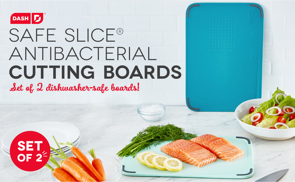 Cutting board with salmon, lemon, and herbs on top of a white counter.