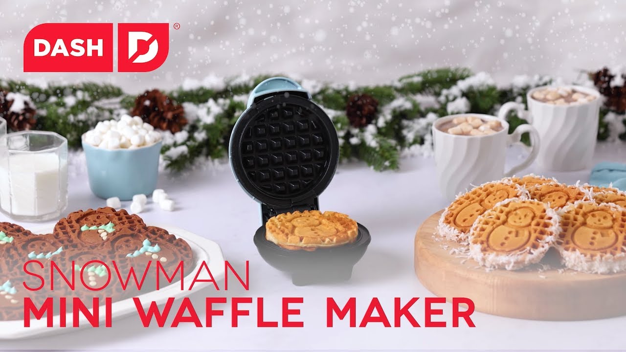 Waffle batter is added to the maker and cooked to make four inch mini waffles with snowman shapes.