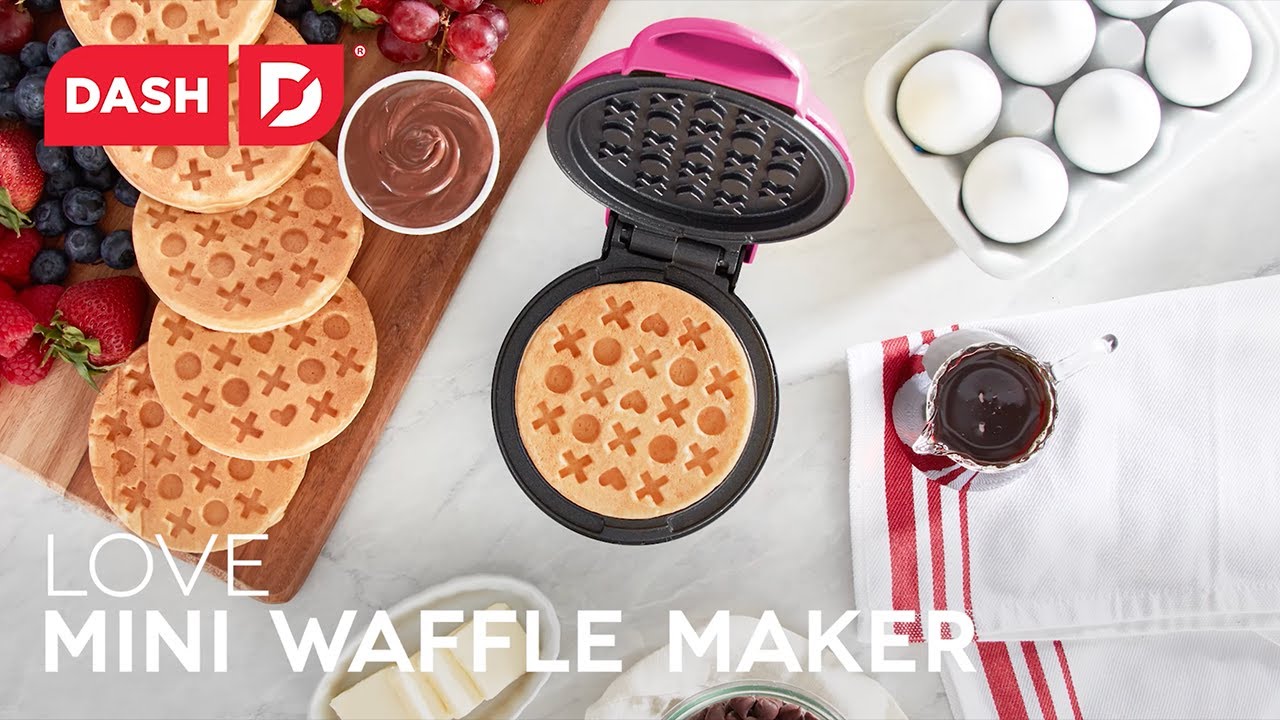 Waffle batter is added to the waffle maker and cooked to create a waffle with an Xs and Os pattern.
